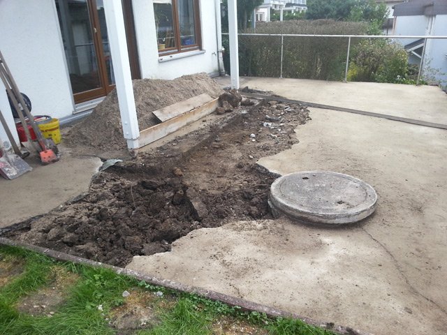 Aufgebrochene, alte Terrassenplatte aus Beton mit Erdaushub vor Beginn einer professionellen Terrassenrenovierung in Bühl